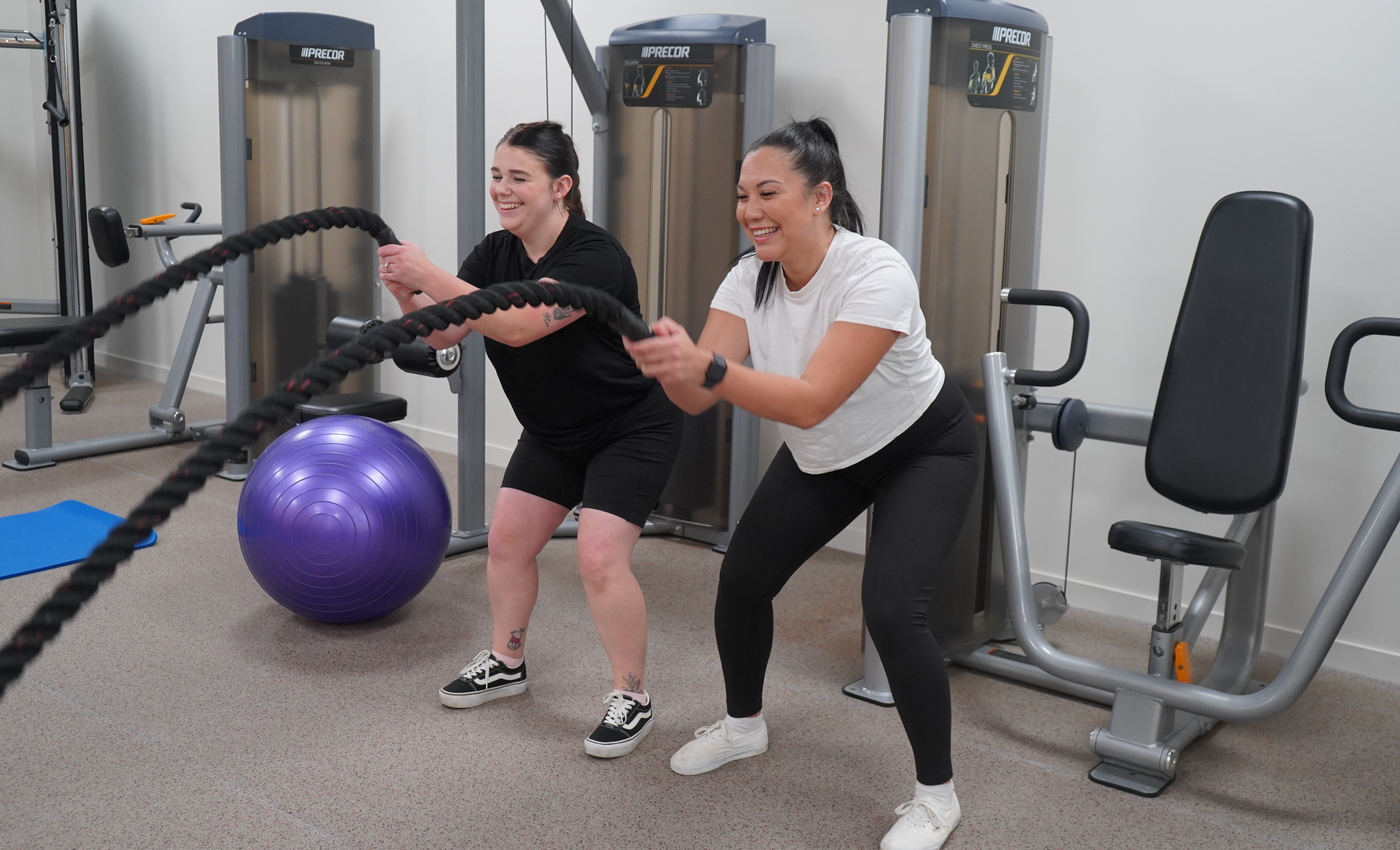 two females work out with a rope