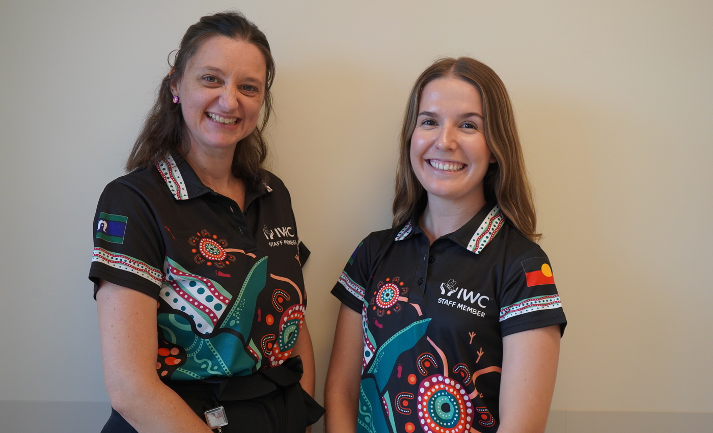 Meg and Zoe standing in front of a wall