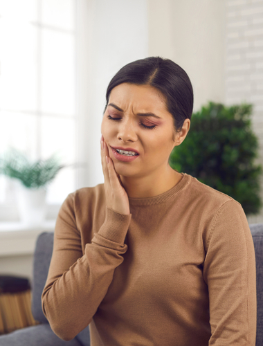 Woman with tooth ache touches her face.