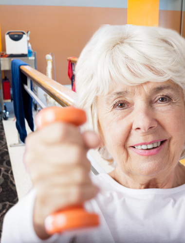 Elderly woman holds a hand weight up