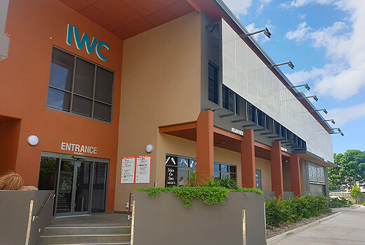 IWC building stands tall behind green shrubbery