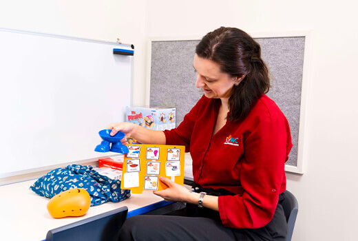 Speech Pathologist holding up word cards