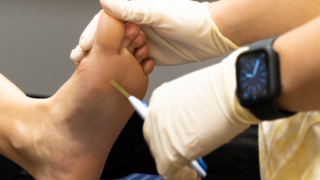 Gloved hand performs diabetes foot check on a foot