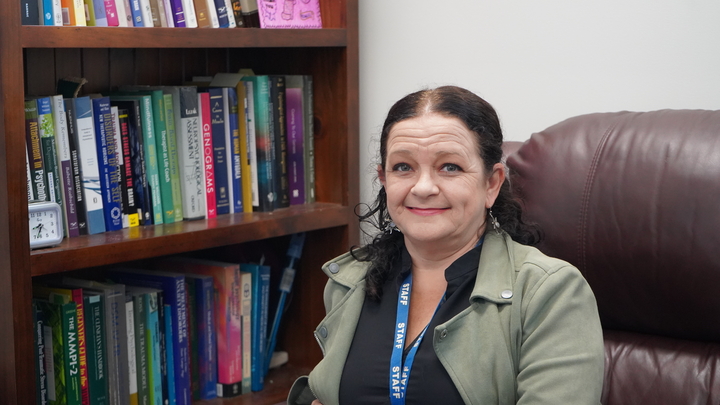 skye wilson sitting in front of bookcase