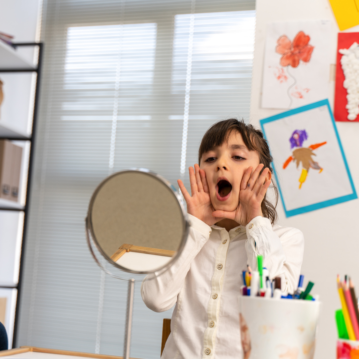 Child uses speech pathology technique in mirror