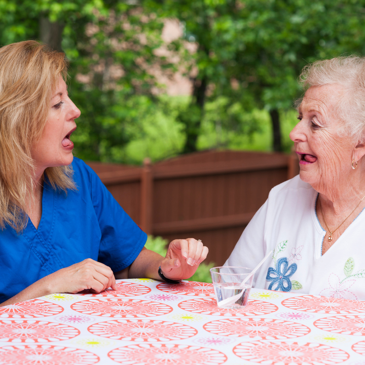 Speech pathologist helps elderly lady with swallowing