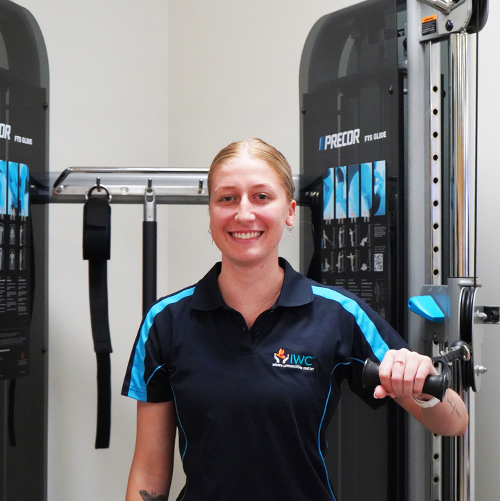 Larah stands with exercise machine