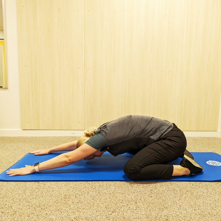 woman performing the stretch "childs pose"