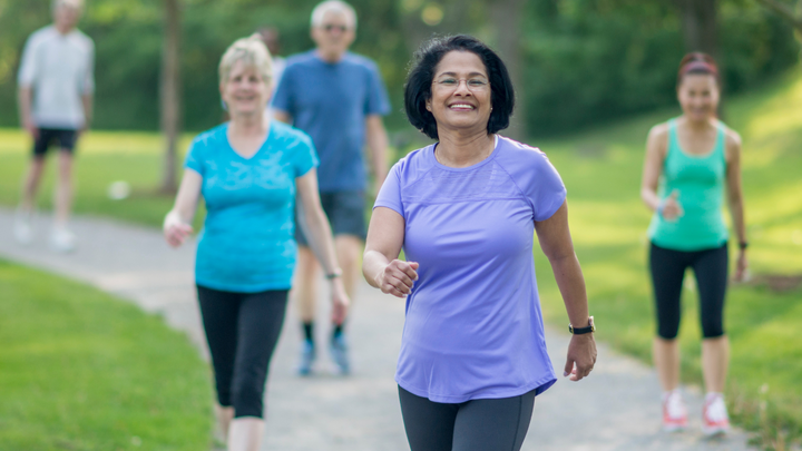 Group of smiling people walk in a park