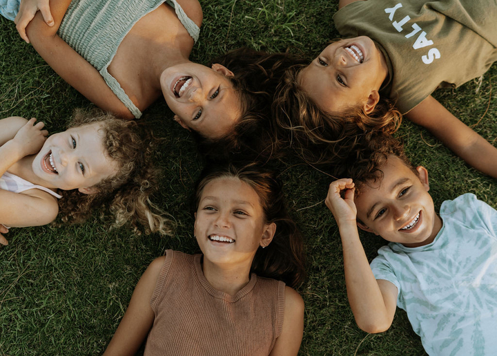 5 children lay on the ground laughing