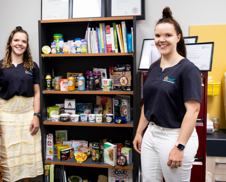 team of 3 dietitians stand beside shelves of food samples