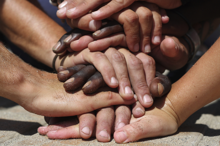 A circle of people hold hands