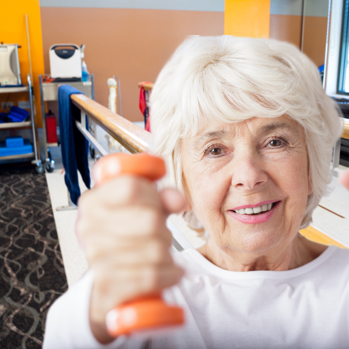elderly woman holds hand weights in a falls prevention class room