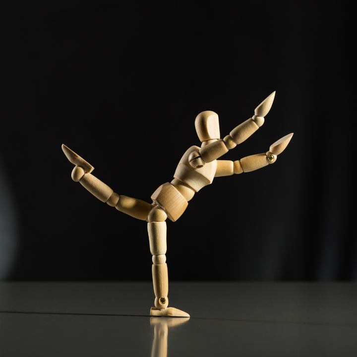 Wooden, moveable statue posed in yoga pose
