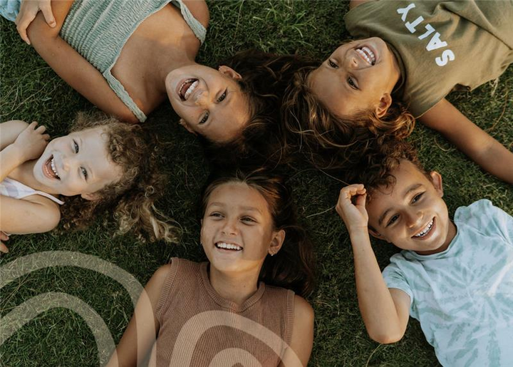 5 children lay on the ground laughing