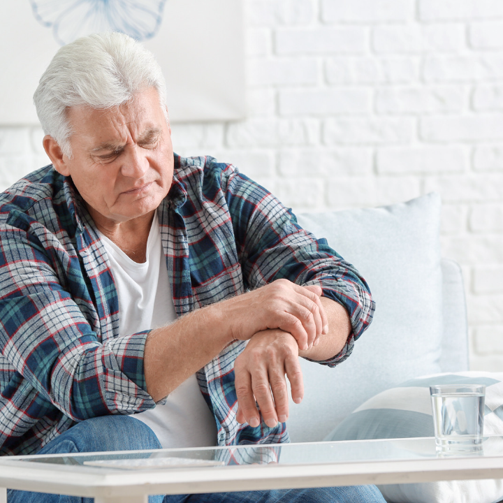 man with parkinson's disease tries to hold hand steady