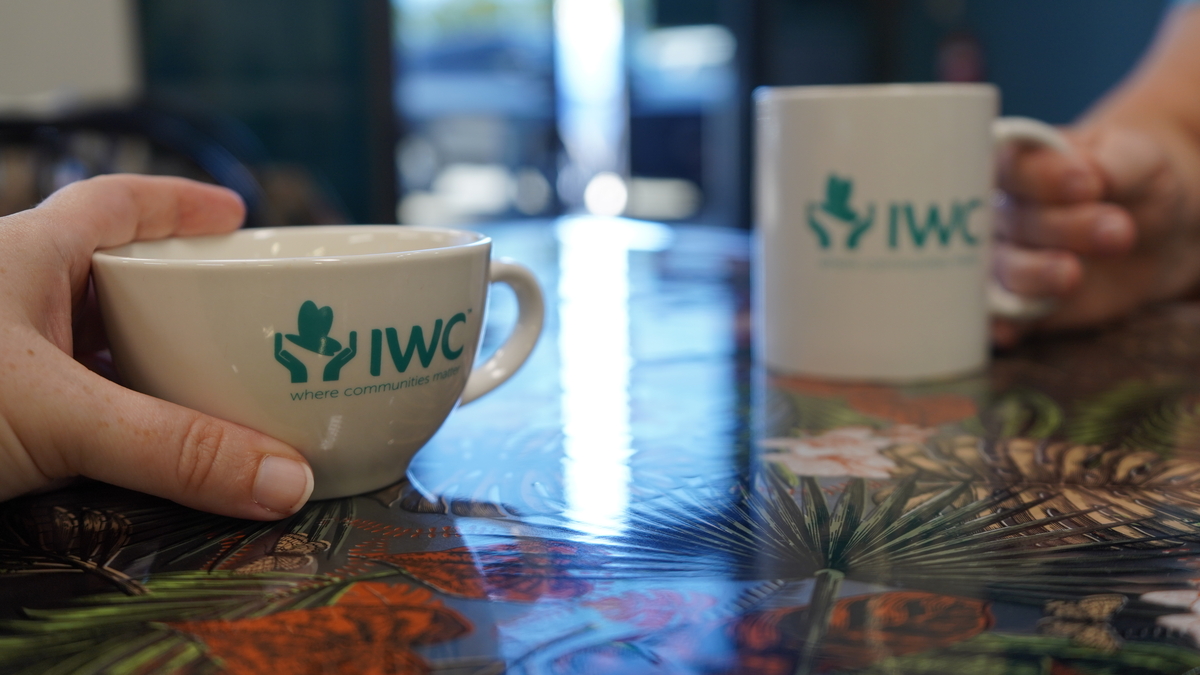 two people hold coffee cups