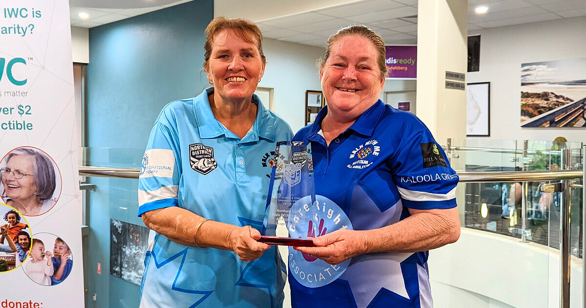 Sonya Olsen and Judy Fenn hold an award in IWC foyer