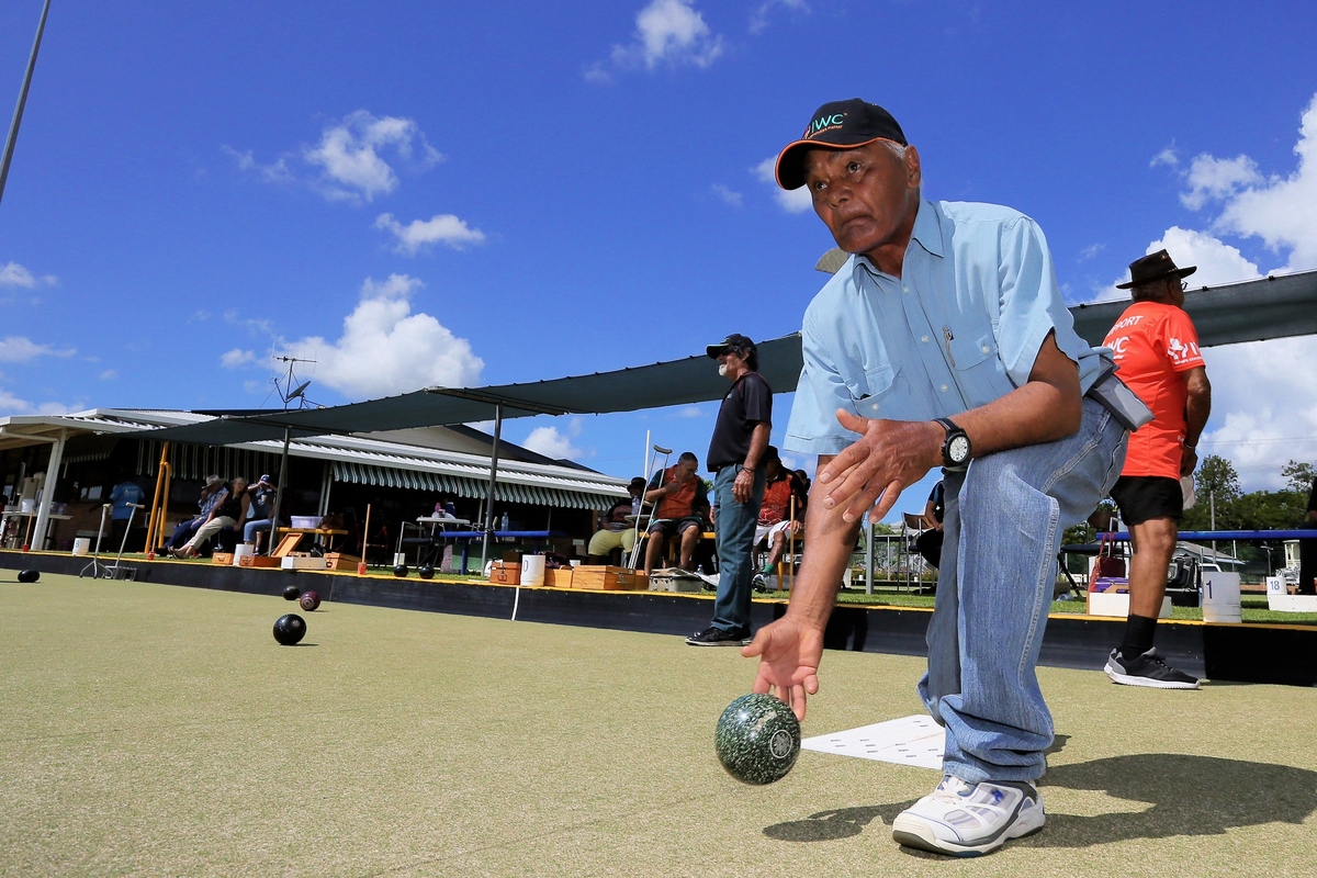 Indigenous Man plays lawn bowls