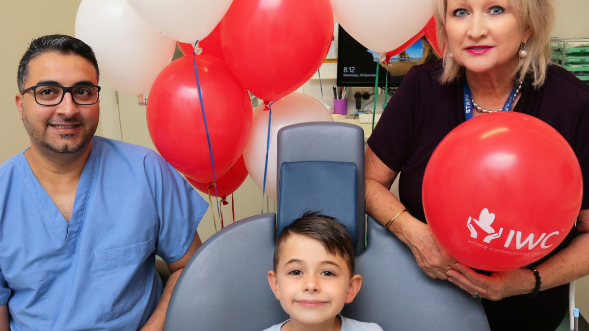 Dentist and Dental Assistant Flank child sitting in Dental Chair.