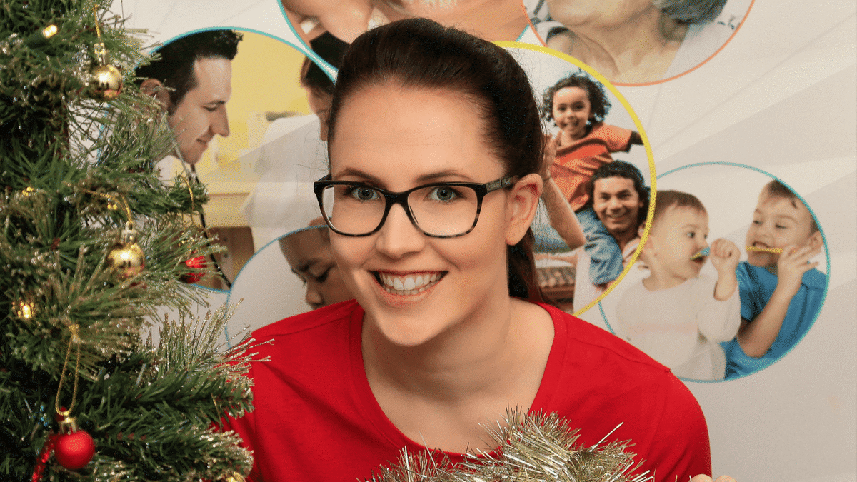 A dietitian sits beside a Christmas tree