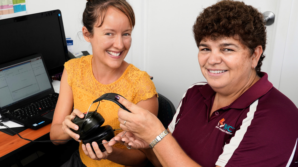 Audiologist and Indigenous Health Practitioner hold Audiology Headphones while smiling