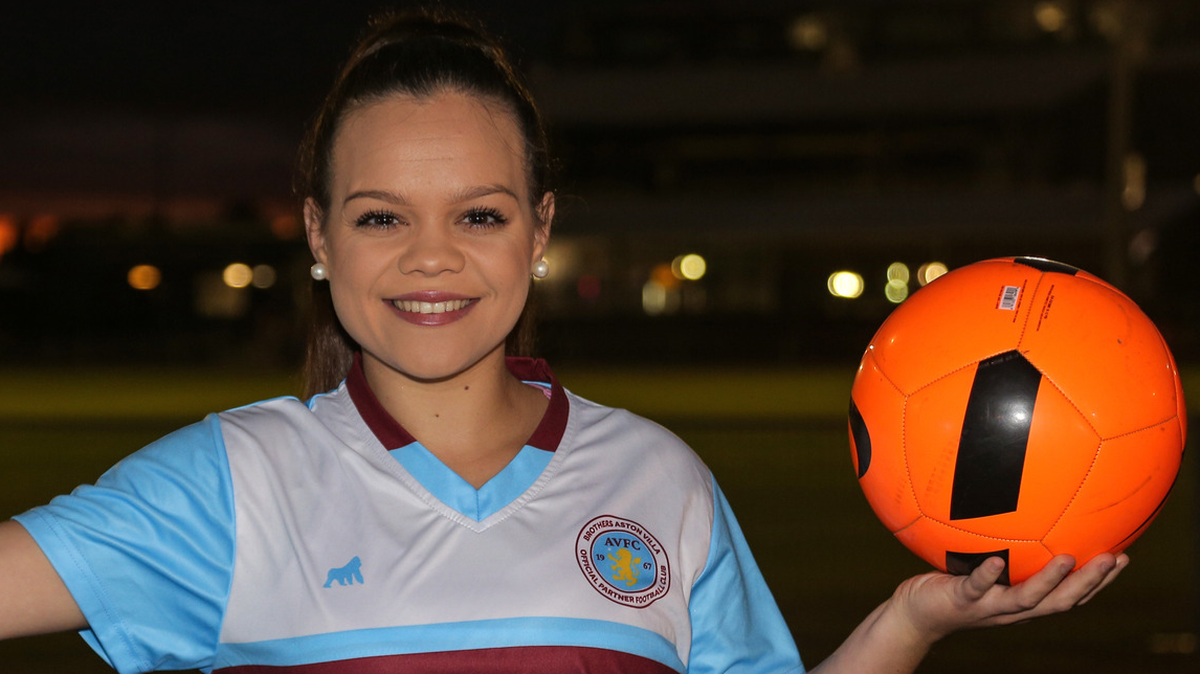 Naidoc Award Winner Smiling at Camera while holding soccer ball.